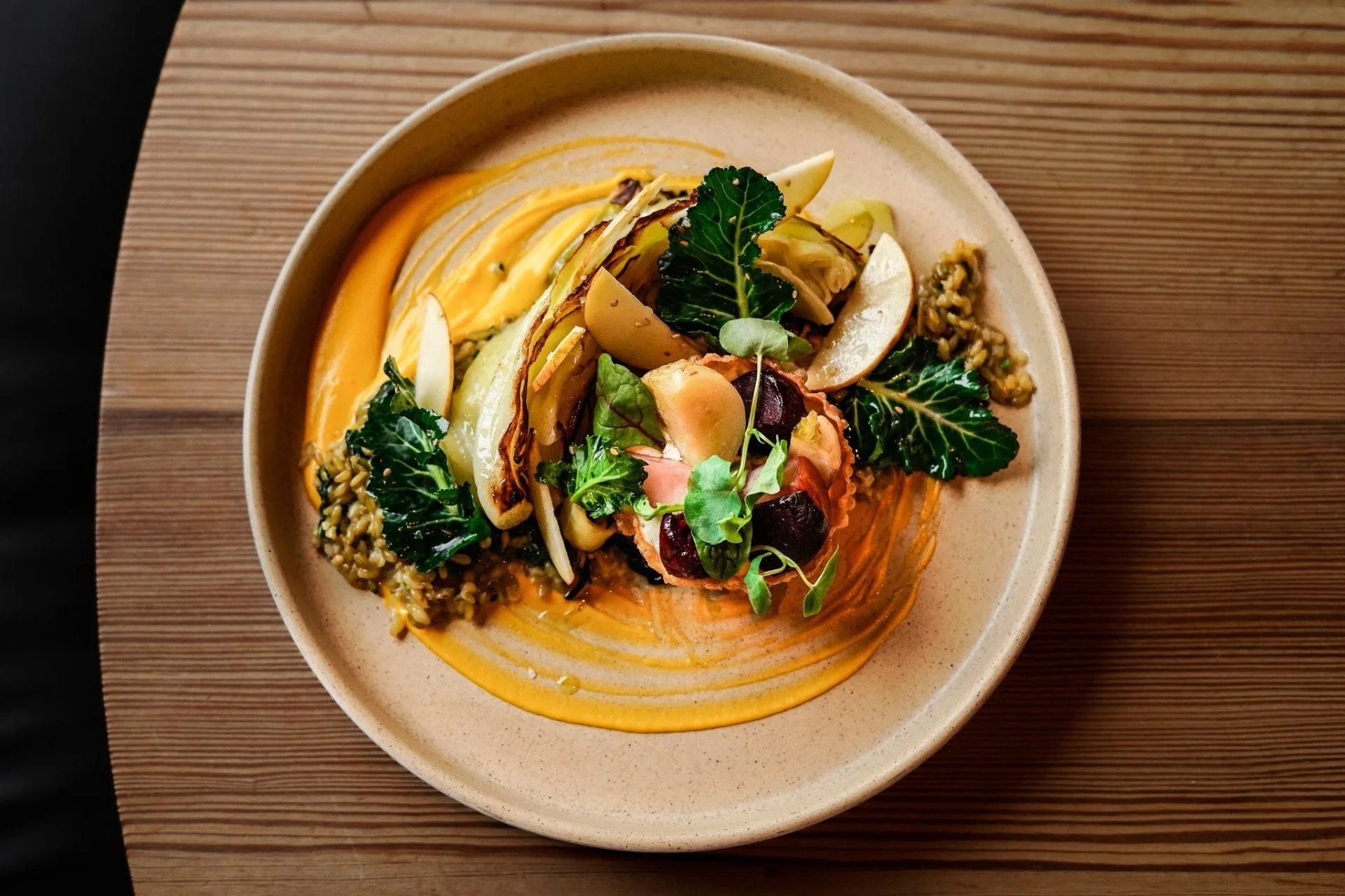 Warmly lit still life of a ceramic bowl and linen on a wooden table — an editorial mood image